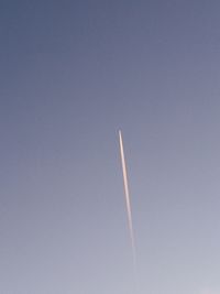 Low angle view of vapor trail against clear blue sky