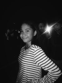 Portrait of smiling woman standing at night