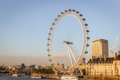 A sunny day in london by the river thames overlooking the iconic london eye