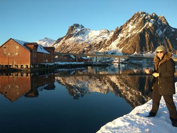 Reflection of woman in lake against clear sky
