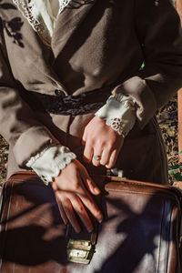 Midsection of woman holding bag while standing outdoors