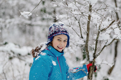 Portrait of smiling girl with snow during winter