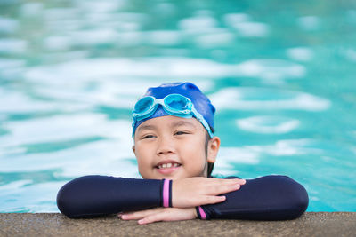 Happy children smiling cute little girl in sunglasses in swimming pool.