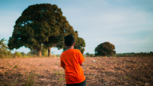 Rear view of boy on field