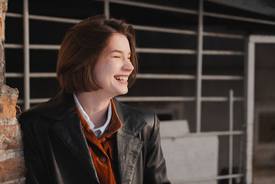 Portrait of smiling young woman looking away outdoors