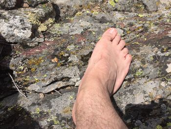 Low section of man relaxing on rock