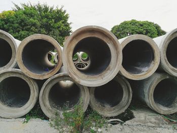 Stack of pipes against sky