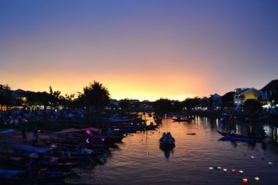 Silhouette boats in lake against clear sky at sunset