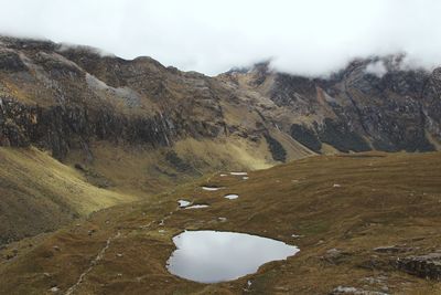 Scenic view of mountains against cloudy sky