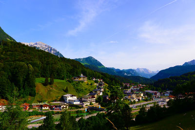 High angle view of houses and mountains against blue sky