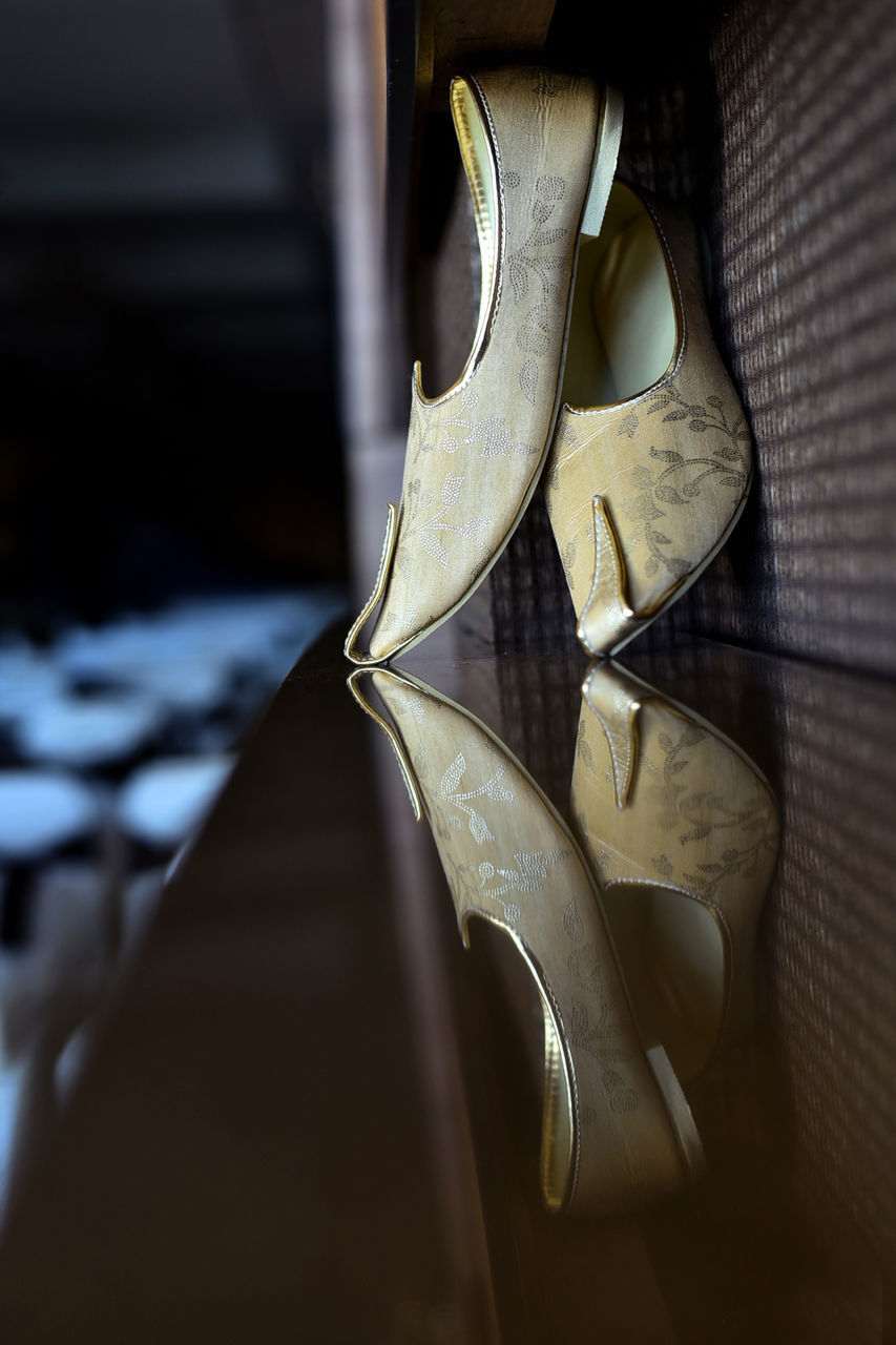 HIGH ANGLE VIEW OF SHOES ON WOODEN TABLE