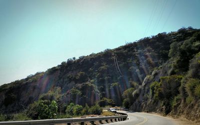 Road leading towards mountains against sky