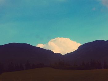 Scenic view of silhouette mountains against blue sky