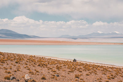 Scenic view of lake against cloudy sky