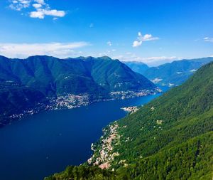 Scenic view of sea and mountains against blue sky