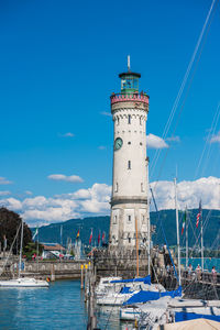 Lighthouse by sea against sky