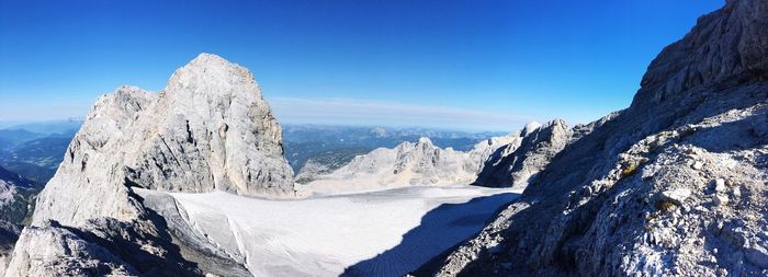 Scenic view of snowcapped mountains against clear blue sky