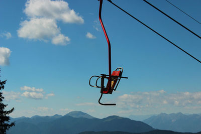 Low angle view of ski lift against blue sky