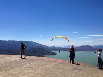 Rear view of woman jumping on mountain