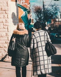 Rear view of people walking on street