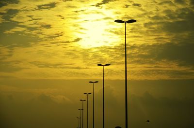 Silhouette street light against yellow sky