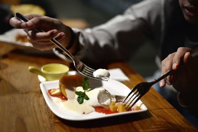 Midsection of man having food in restaurant