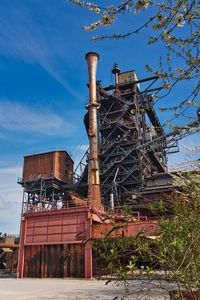 Low angle view of abandoned factory against sky