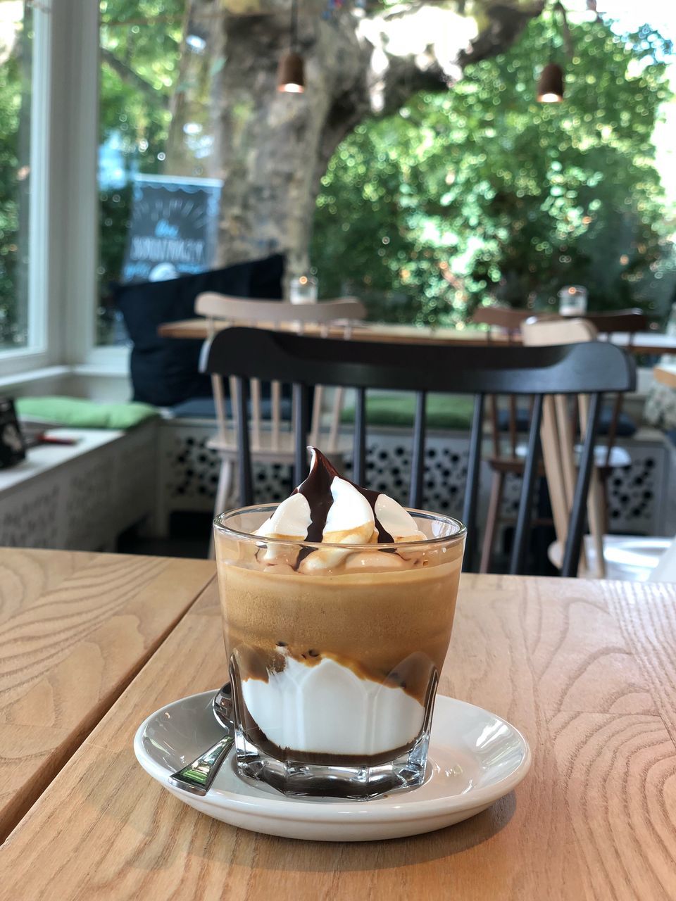 CLOSE-UP OF COFFEE CUP ON TABLE AGAINST CAFE