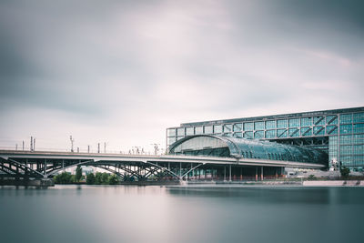 Berlin hauptbahnhof railway station over river against cloudy sky