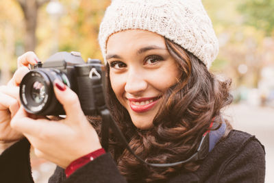 Portrait of smiling woman holding camera