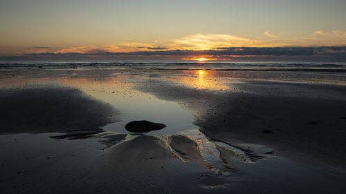 Scenic view of beach against sky during sunset