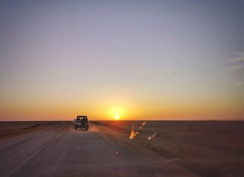 Car on road against sky during sunset