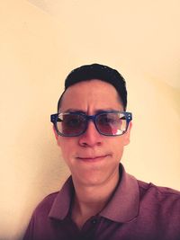 Portrait of smiling young man against wall