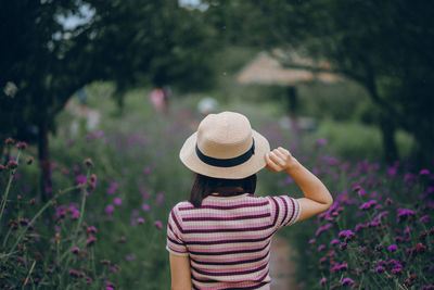 Midsection of woman wearing hat against plants