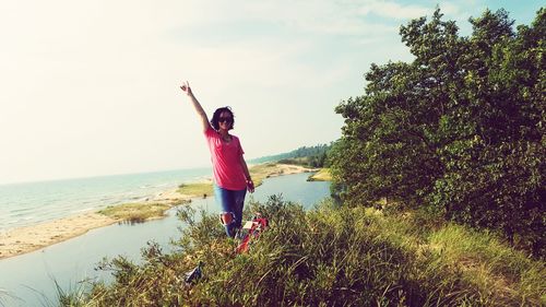 Woman standing by sea against sky