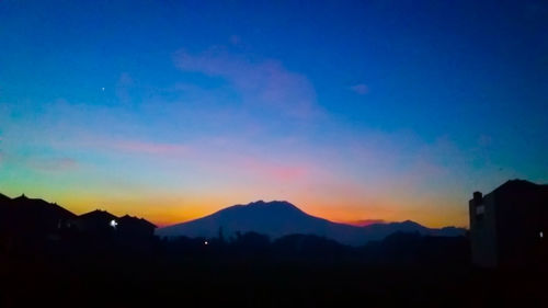 Scenic view of silhouette mountains against sky at sunset