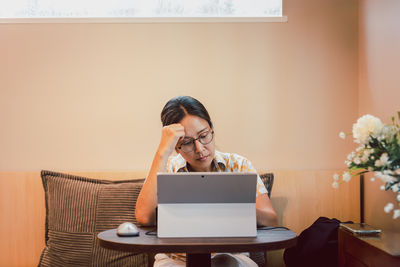 Young woman using laptop at home