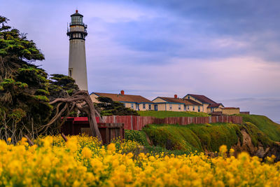 Lighthouse on field against sky