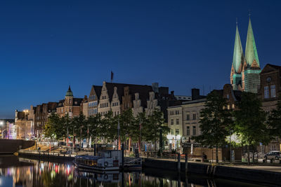 View of buildings at waterfront during dusk 