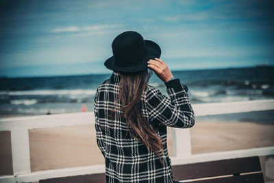 Rear view of woman standing against sea