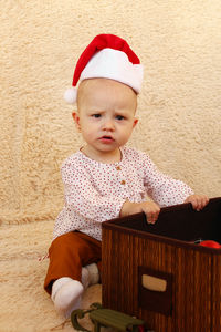 Portrait of cute girl sitting on sofa at home