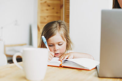 Portrait of girl sitting on table