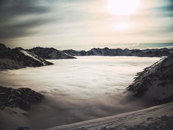 Scenic view of sea and mountains against dramatic sky