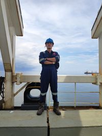 Full length of man standing on smart phone against sky