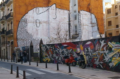 Men hanging on wall in city