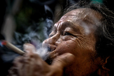 Close-up of senior man smoking cigarette