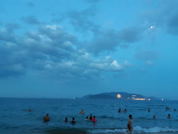 People on beach against sky