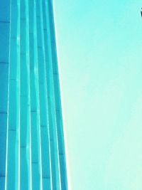 Low angle view of tall building against clear blue sky