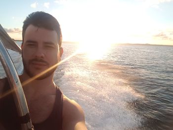 Portrait of man in sea against sky during sunset