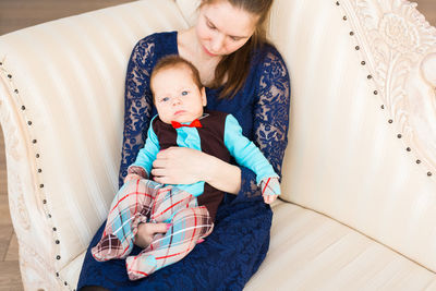 Mother and daughter sitting on bed